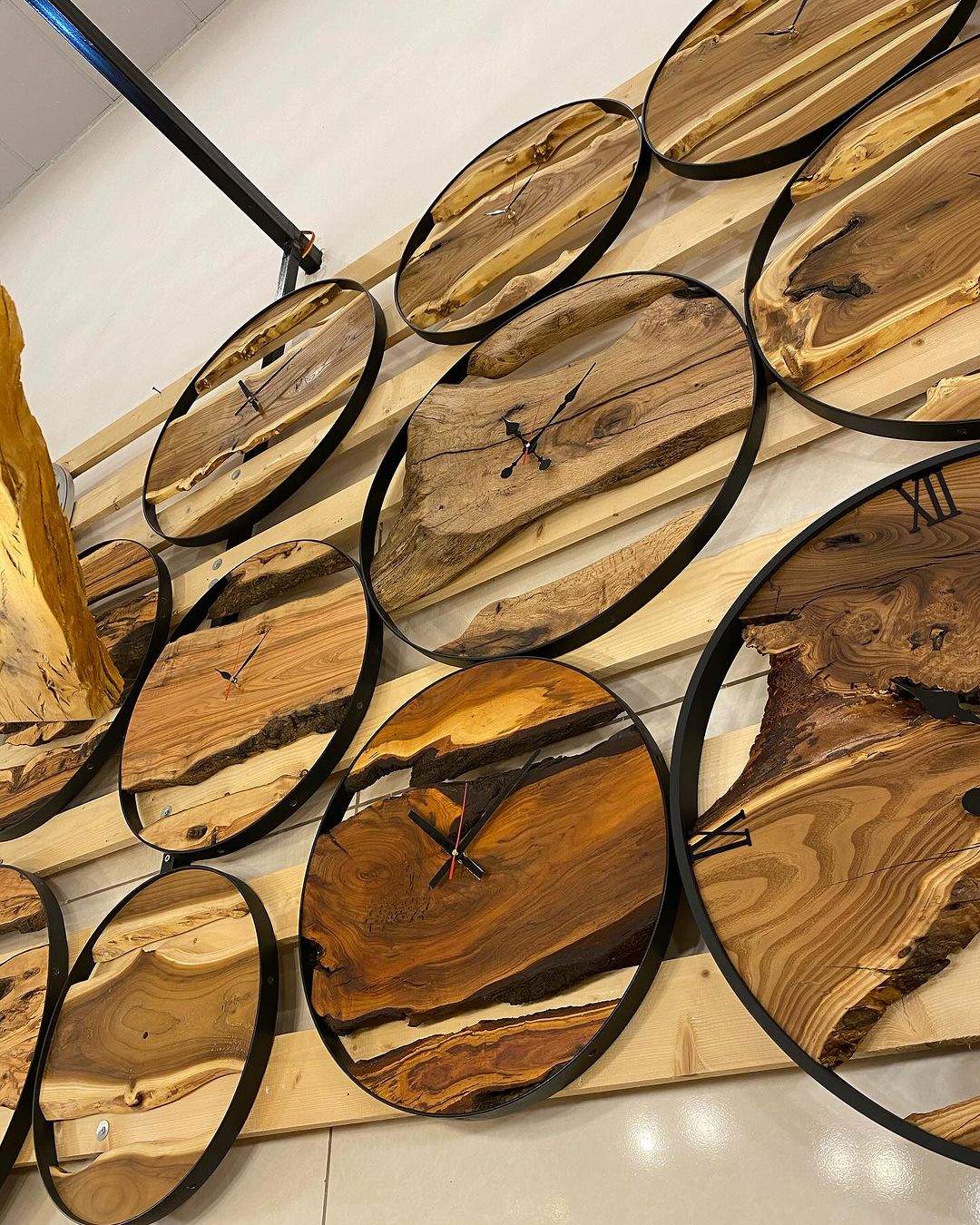 A selection of unique wooden wall clocks with natural edges encased in black circular frames, showcasing organic beauty and modern design.