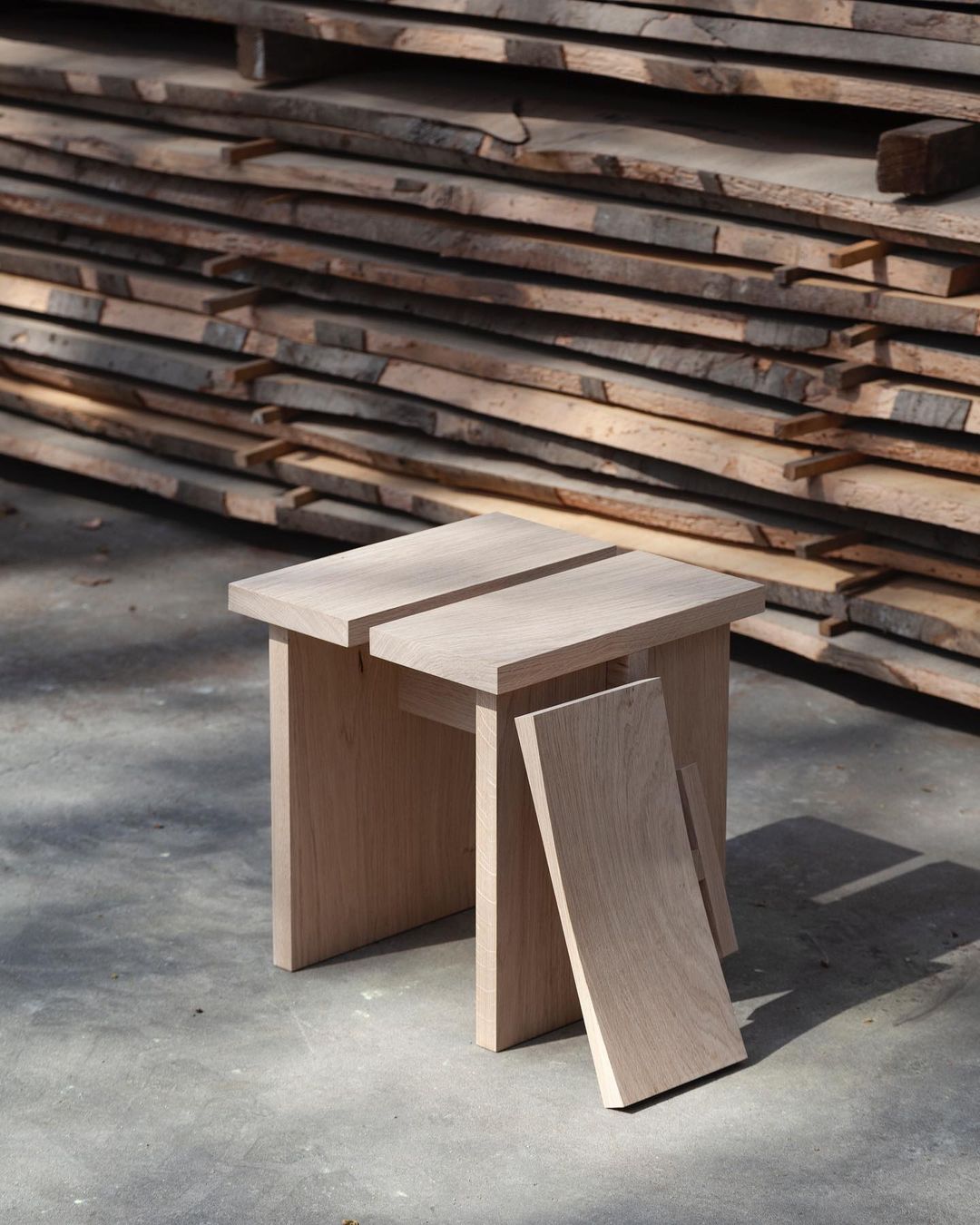 A modern minimalist wooden stool with an innovative cantilever design