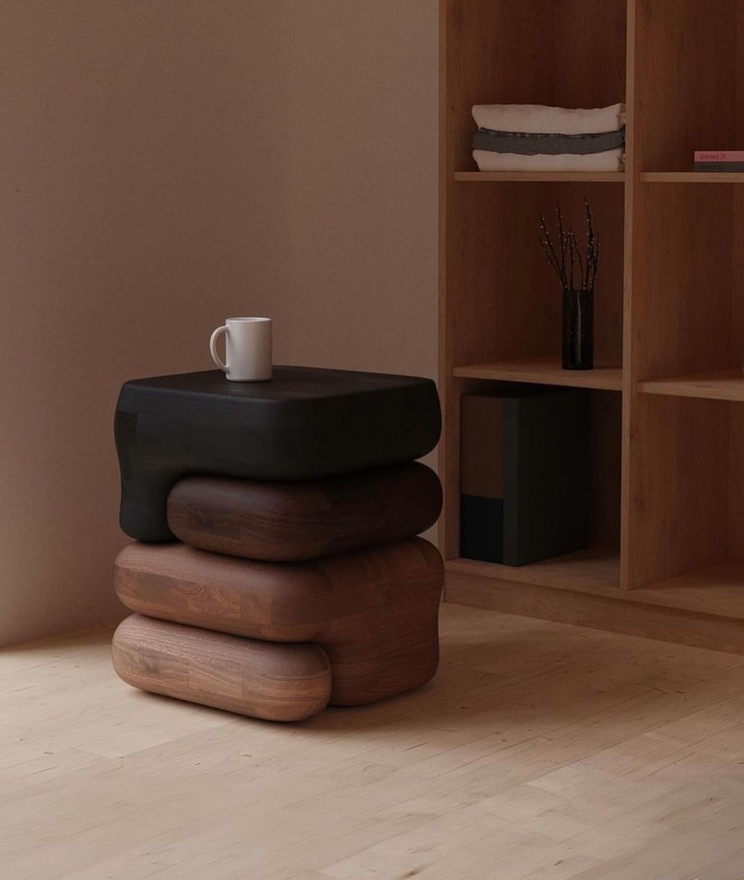 A unique and sculptural wooden side table comprised of three stacked, rounded forms in varying wood tones.