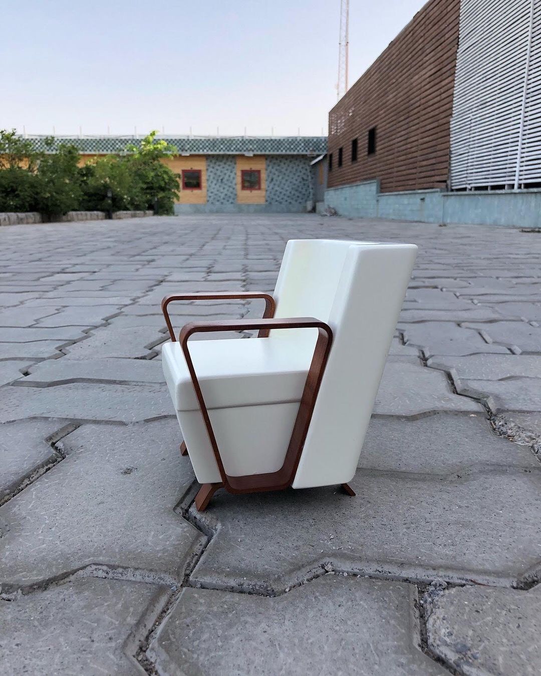 A distinctly modern outdoor chair with a white finish and brown accents