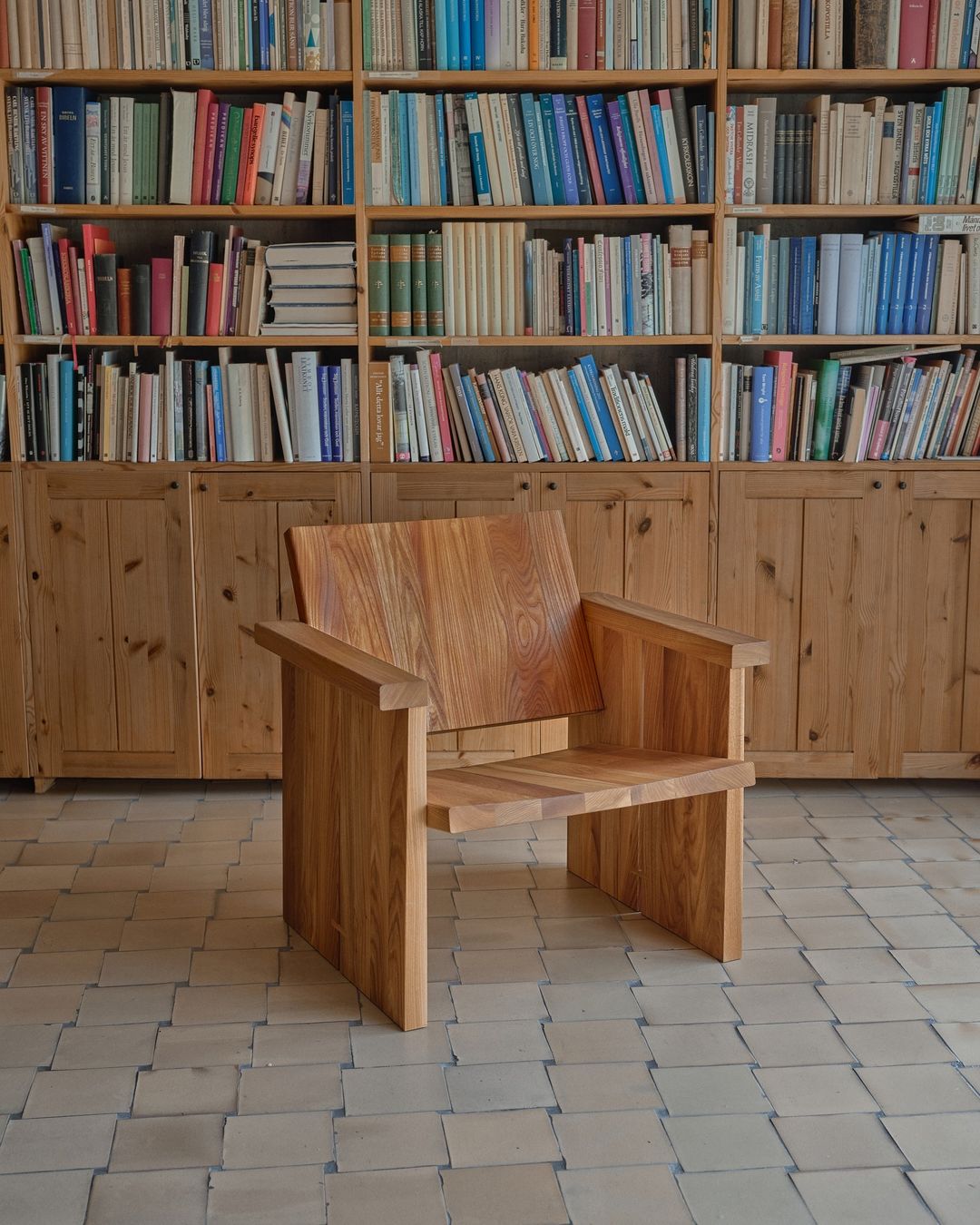 A wooden chair in front of a bookshelf