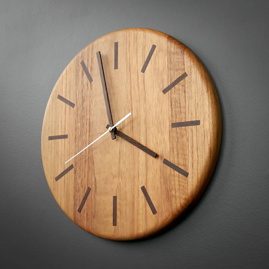 Minimalistic wooden wall clock on a grey background