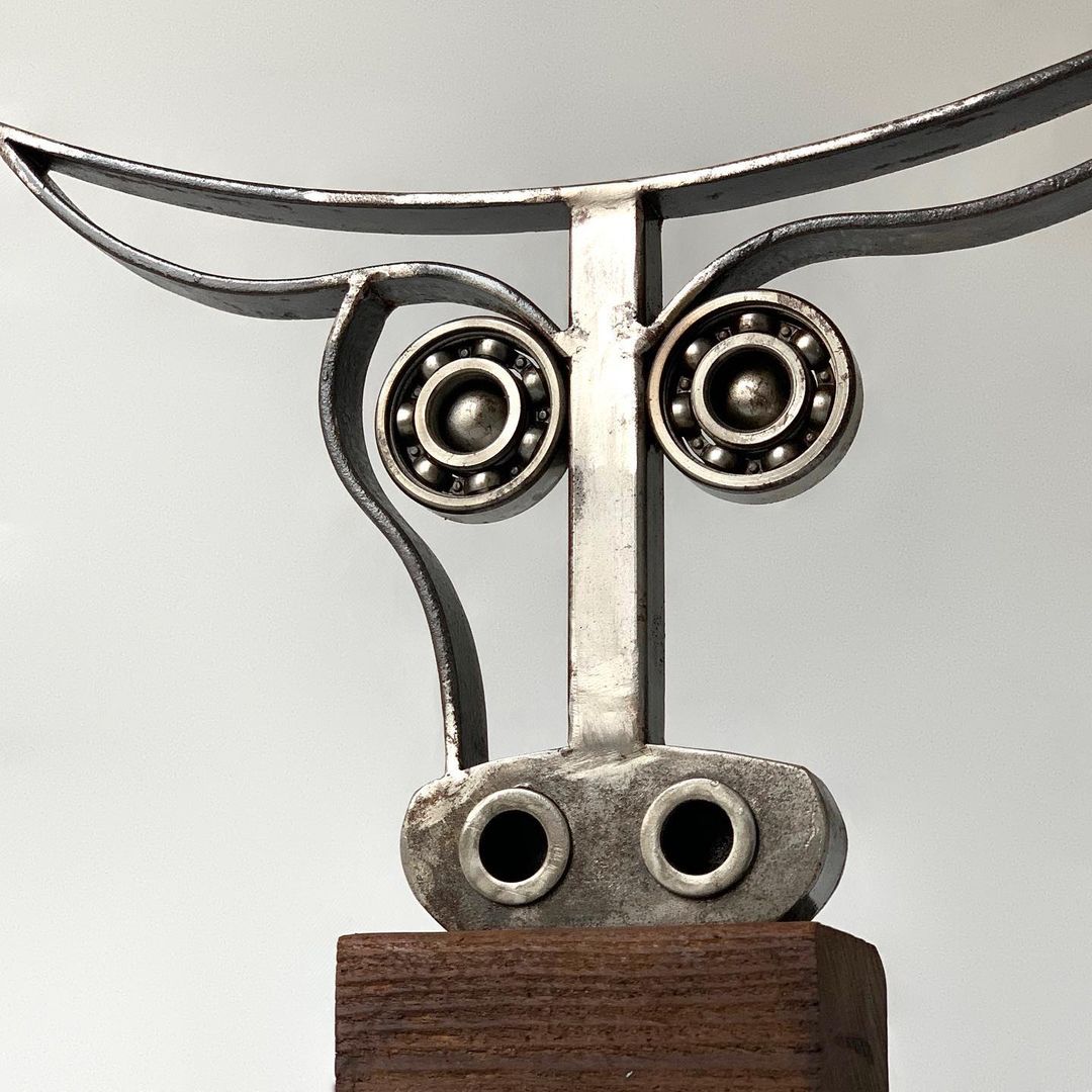 Abstract metal sculpture resembling a playful, curious character