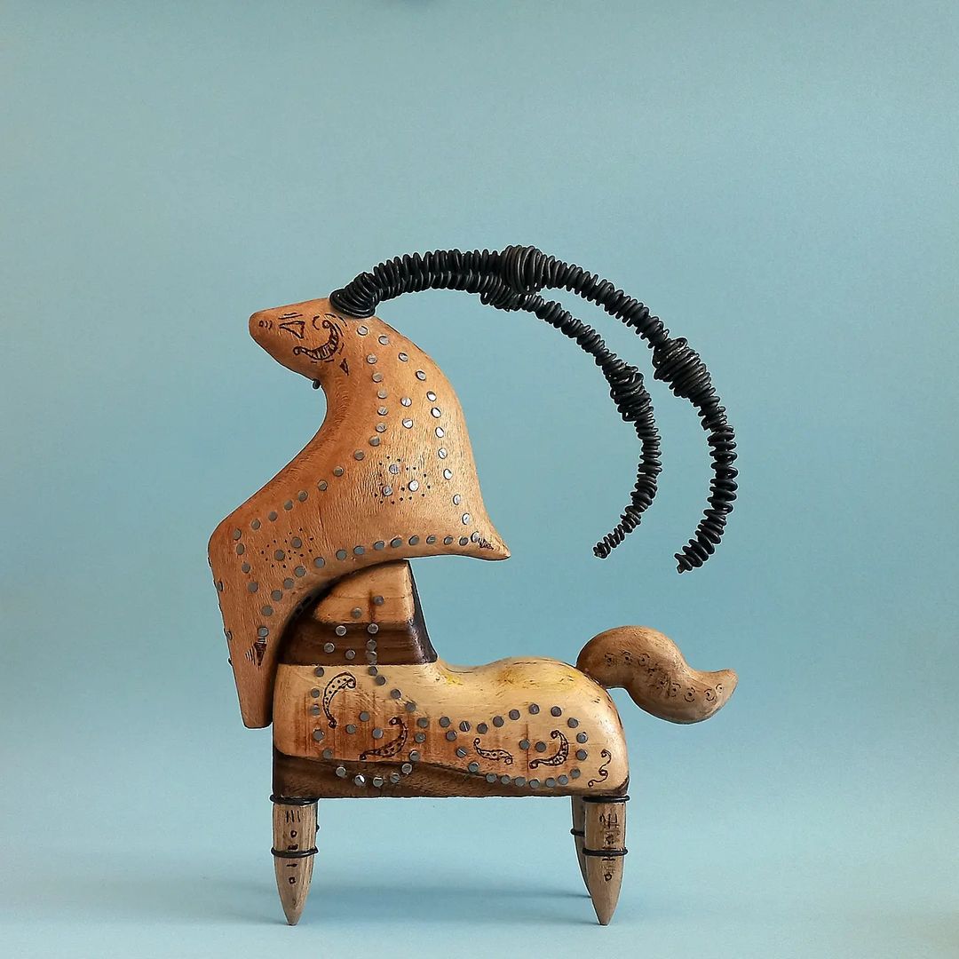 An abstract wooden sculpture featuring a stylized animal with a spiraled horn