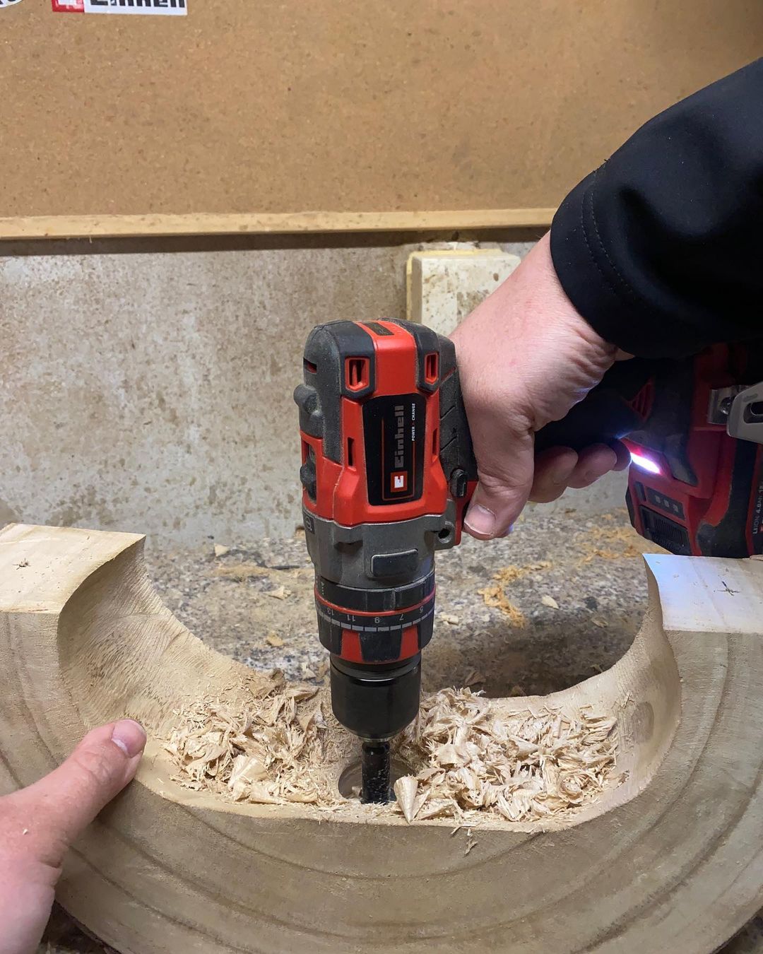 Person working with a drill on a wooden surface