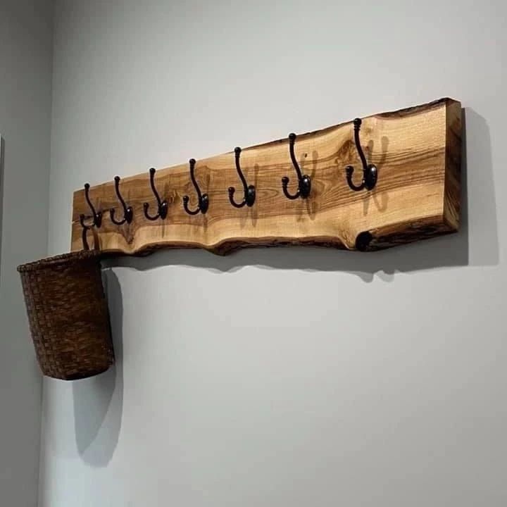 A uniquely designed coat rack crafted from a portion of raw wood with an attached rustic basket