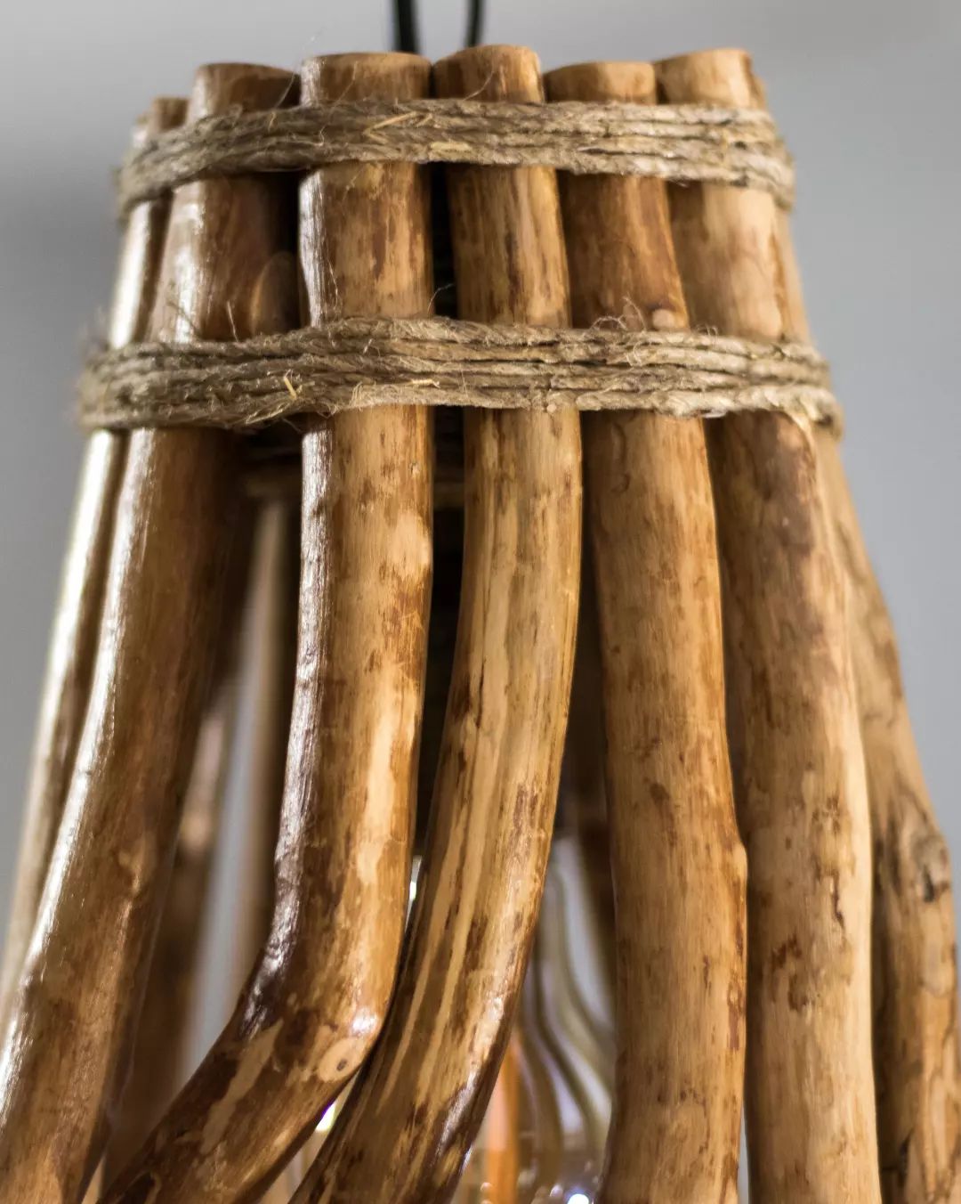 Detail of a handcrafted object featuring natural wooden elements bound with twine