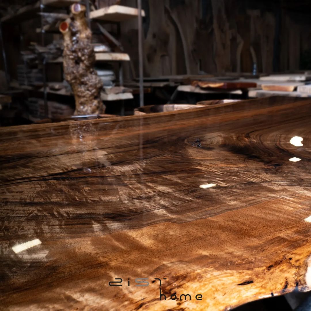 A richly textured slab of walnut with natural edges and a high-gloss finish, showcasing the beauty of wood craftsmanship