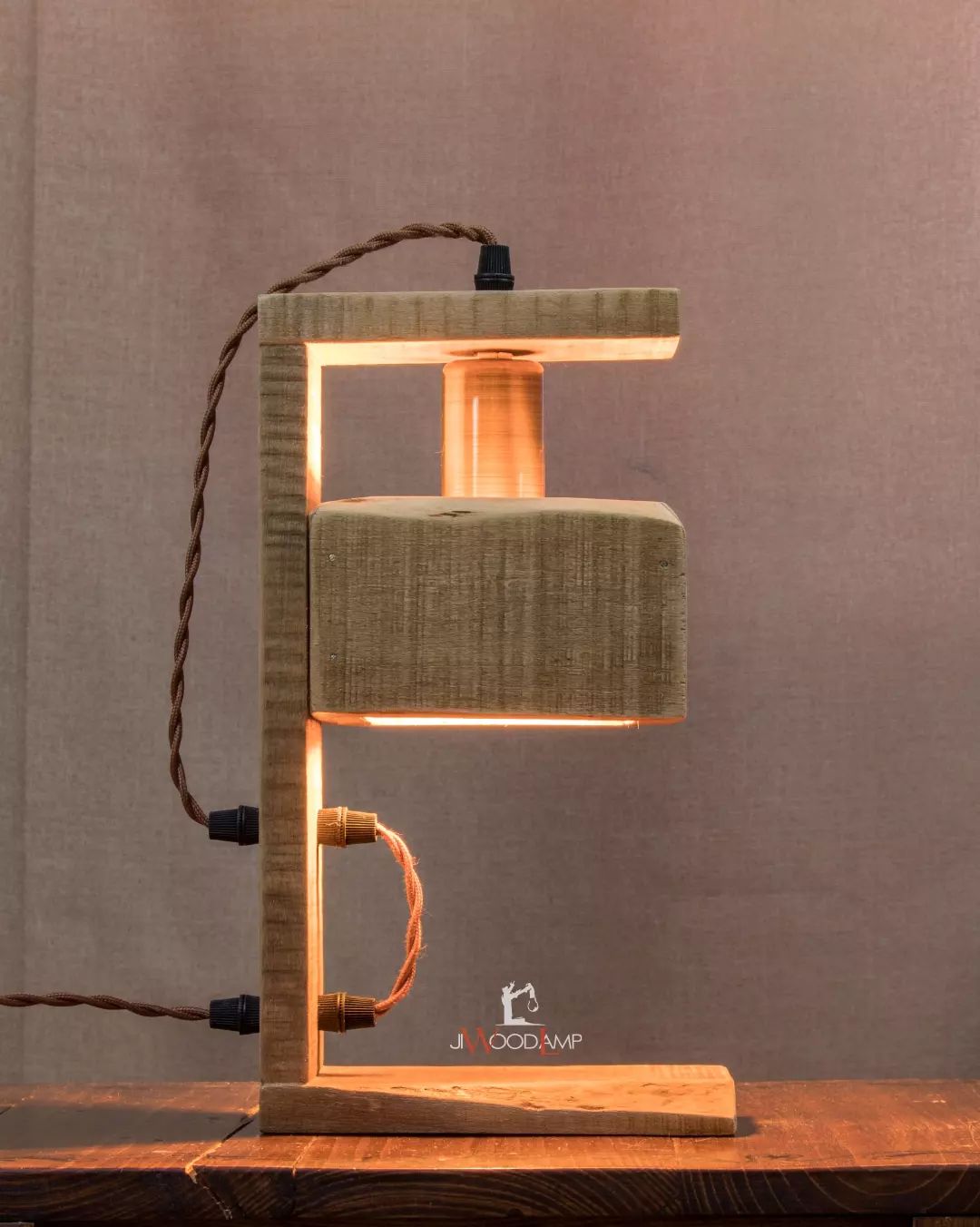 A unique wooden table lamp with a fabric shade and intertwined rope design elements.