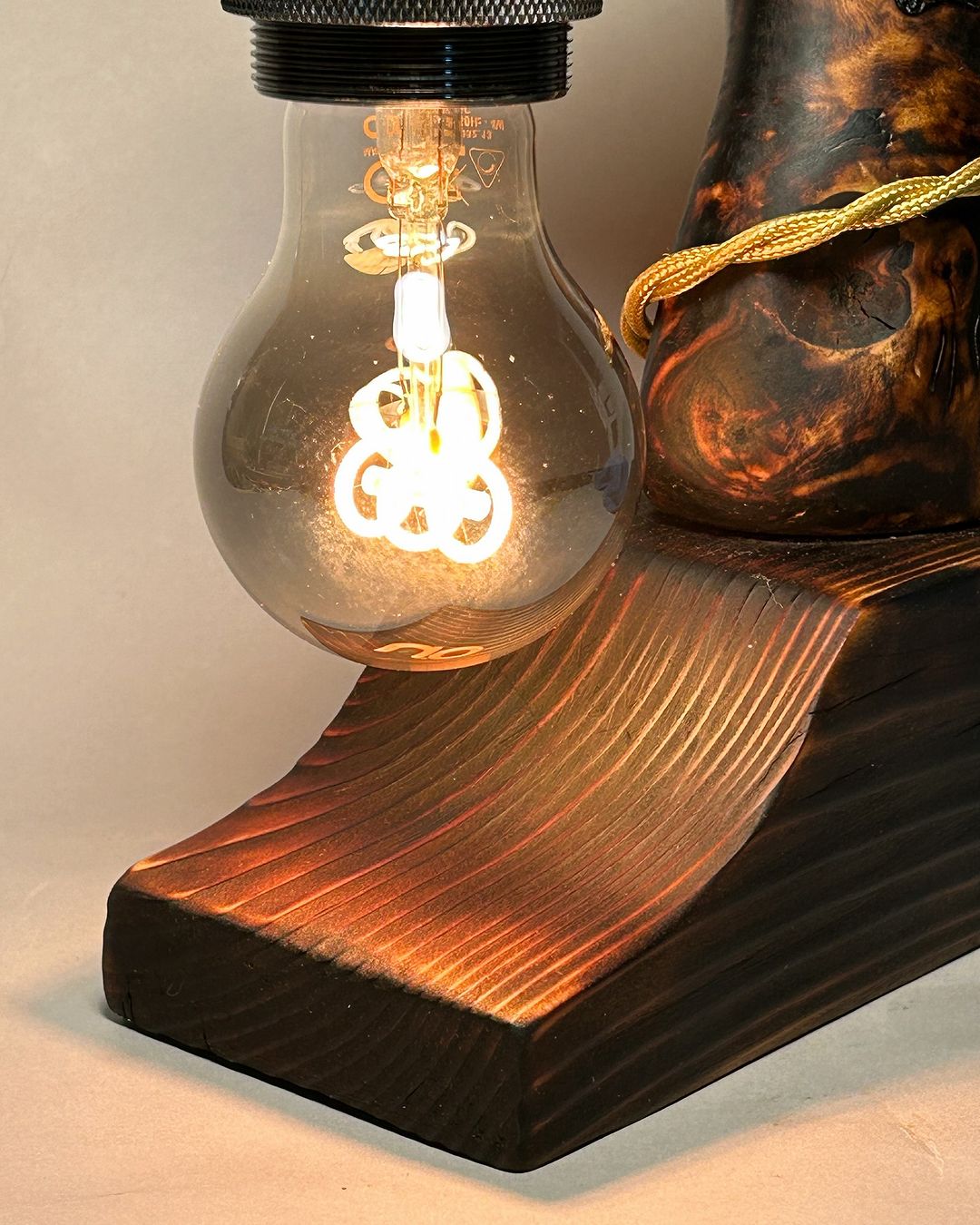 A unique lamp design with a glowing filament bulb