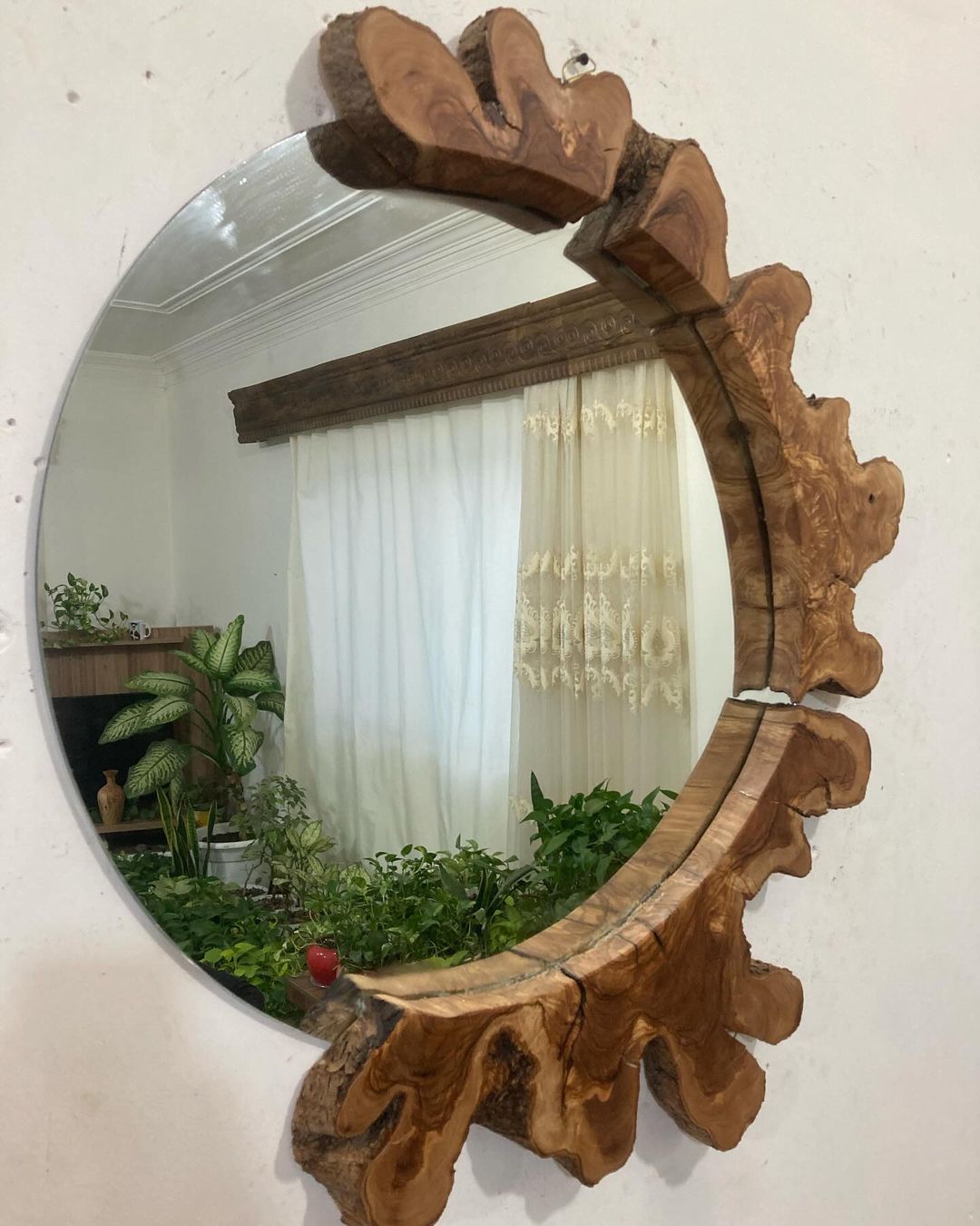 A uniquely crafted mirror with a natural wood frame