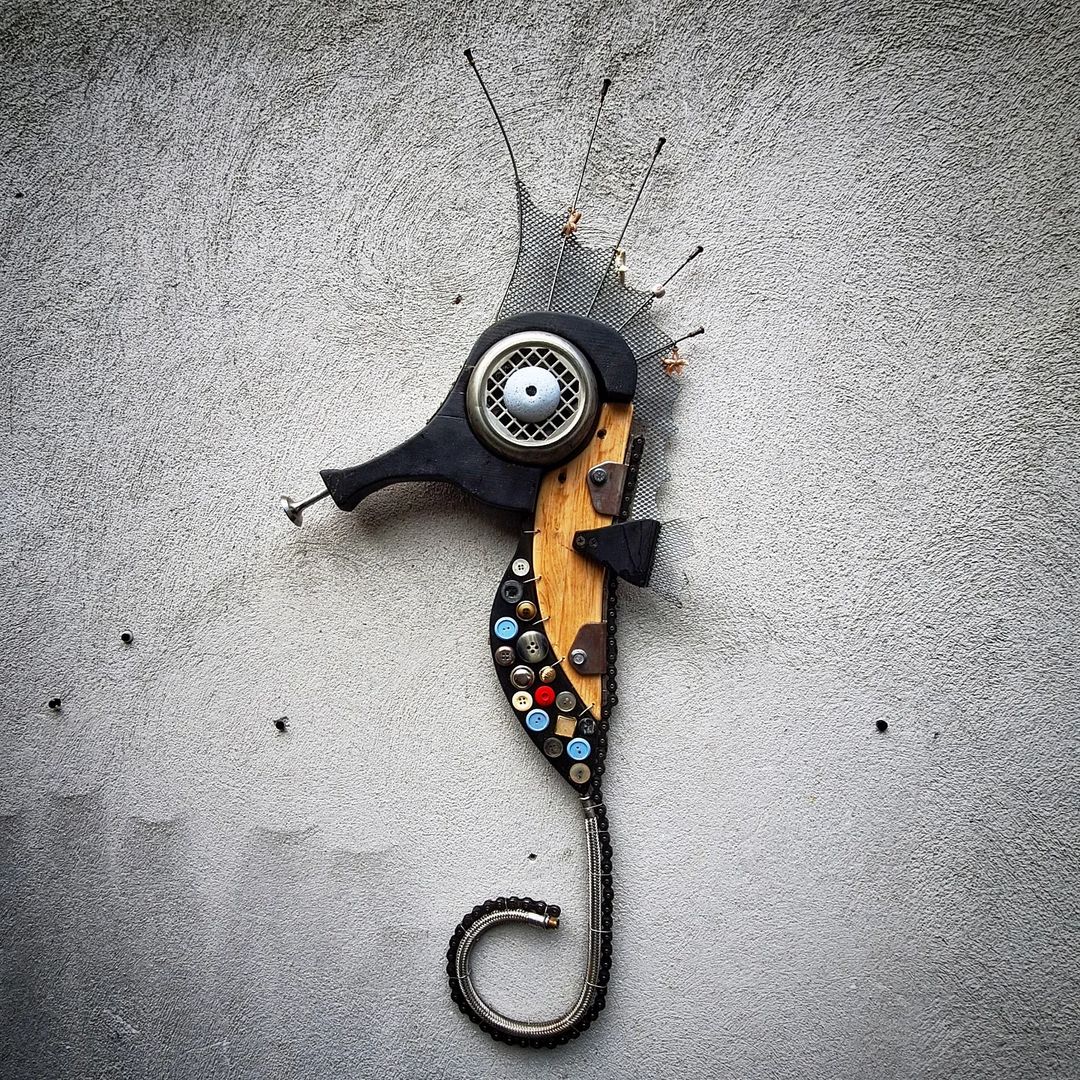 An imaginative wall-mounted sculpture comprised of various objects assembled to resemble a seahorse