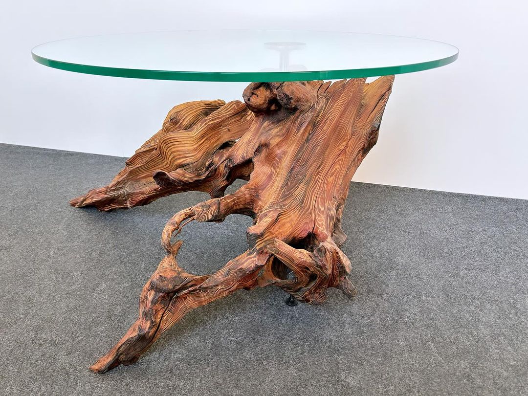 A uniquely crafted table with a wood base and a glass top