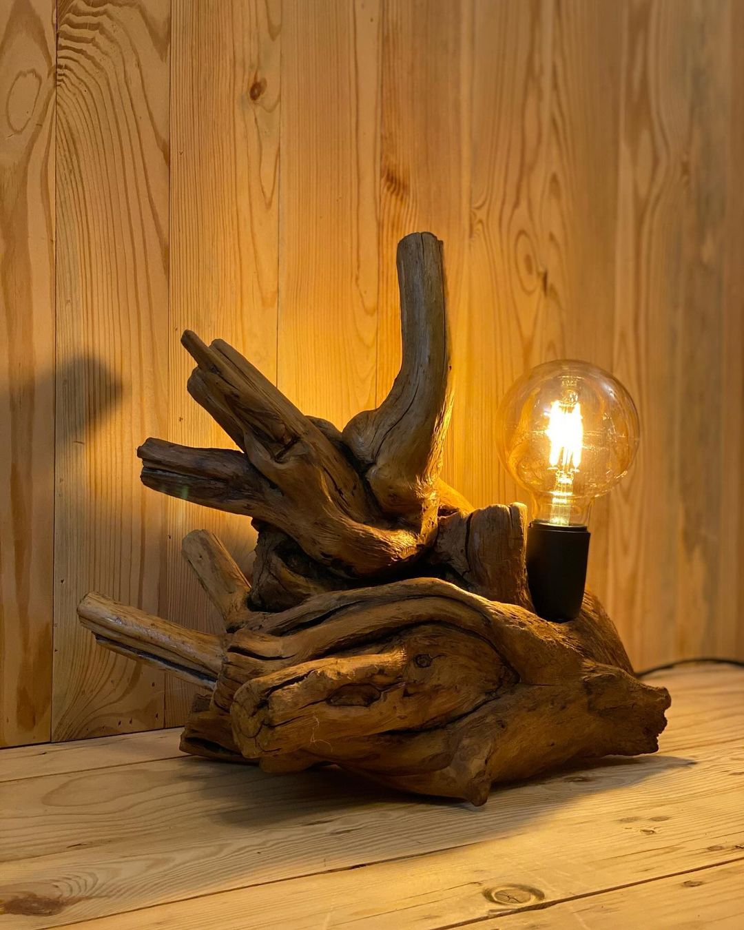 A unique wooden lamp crafted from driftwood, illuminating the space with a warm glow.