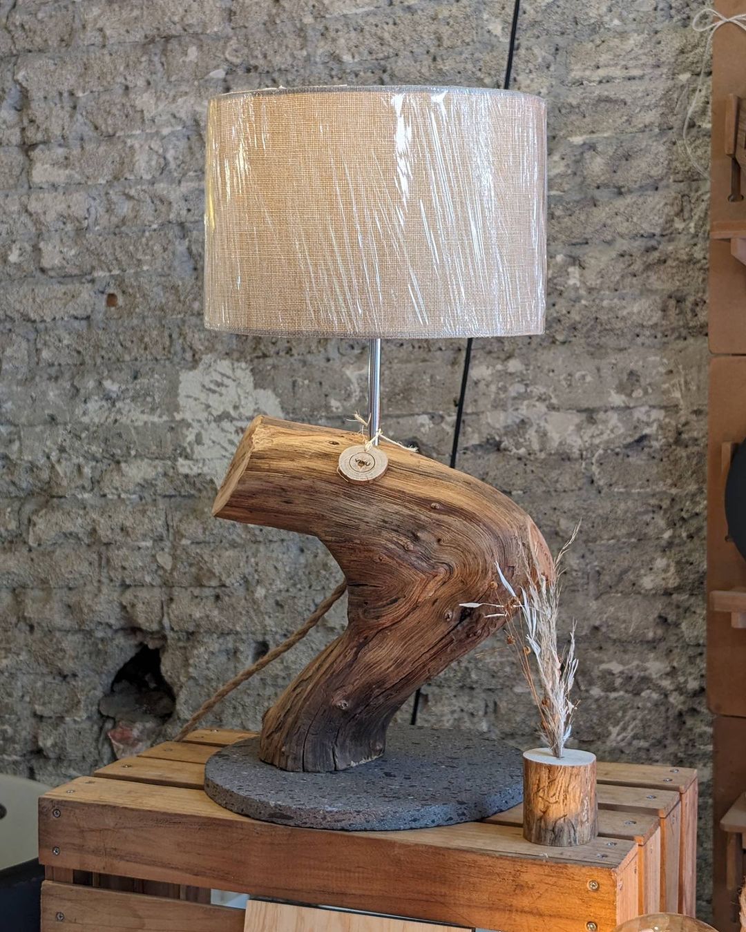 A unique lamp with a rustic wooden base and a beige shade