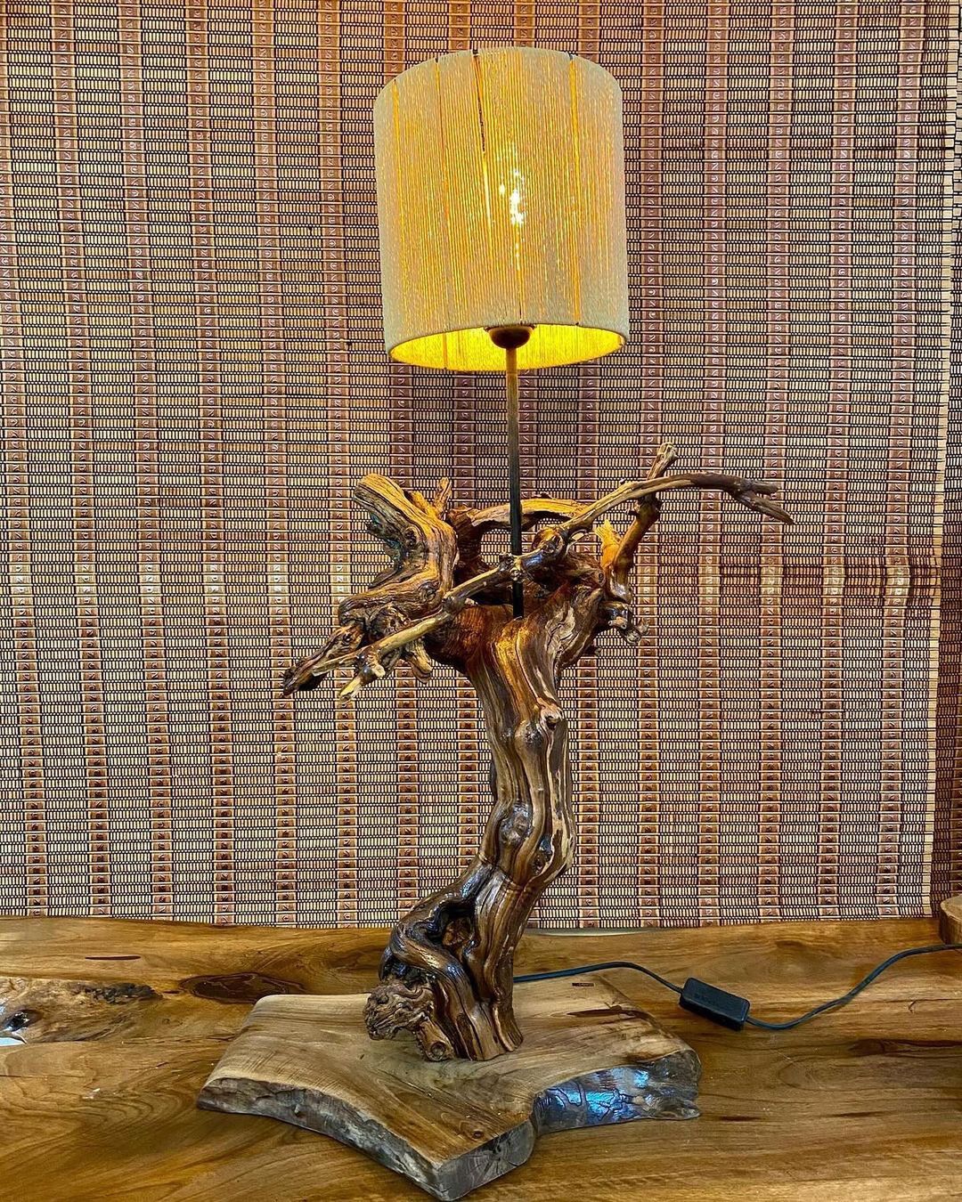 A uniquely crafted wooden lamp with a freeform base