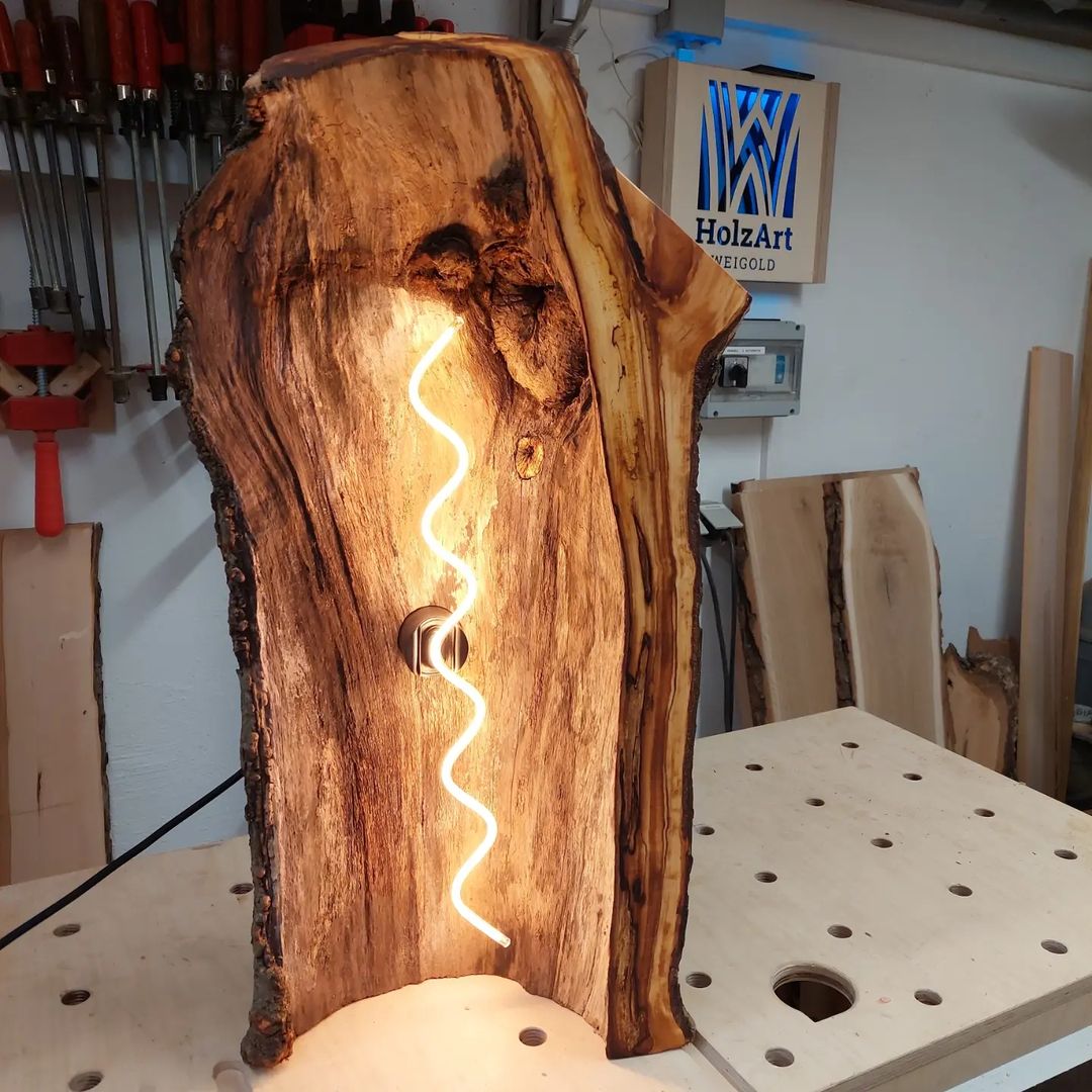 A unique wooden lamp with a carved twist design emitting a warm glow