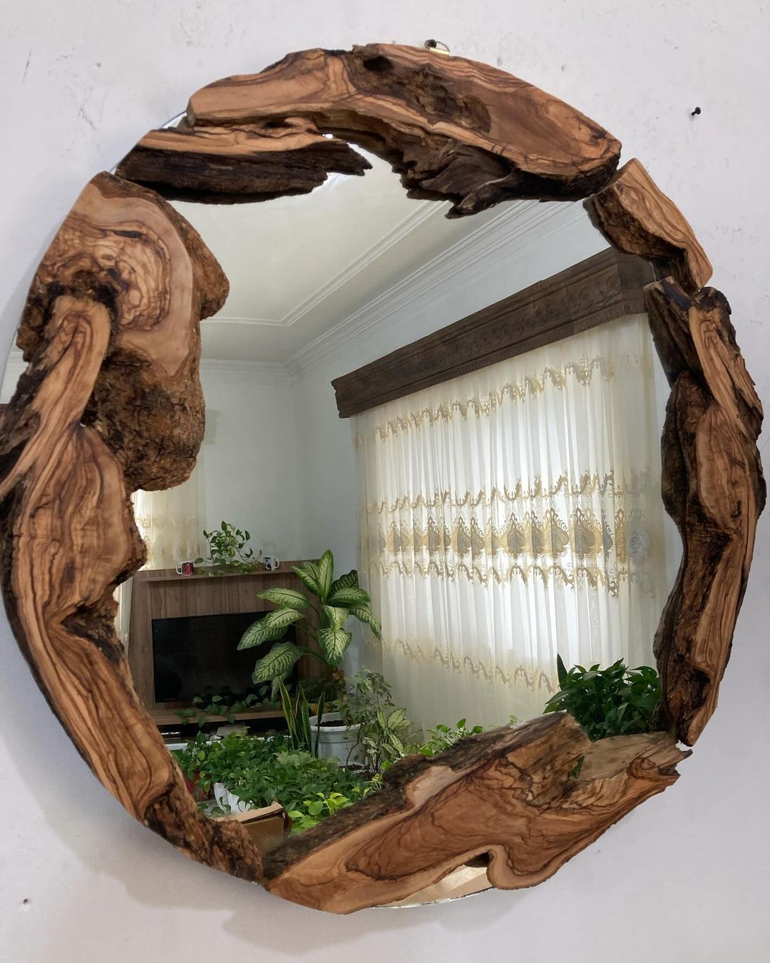 A uniquely crafted wooden mirror frame adds a natural and artistic touch to the interior decor