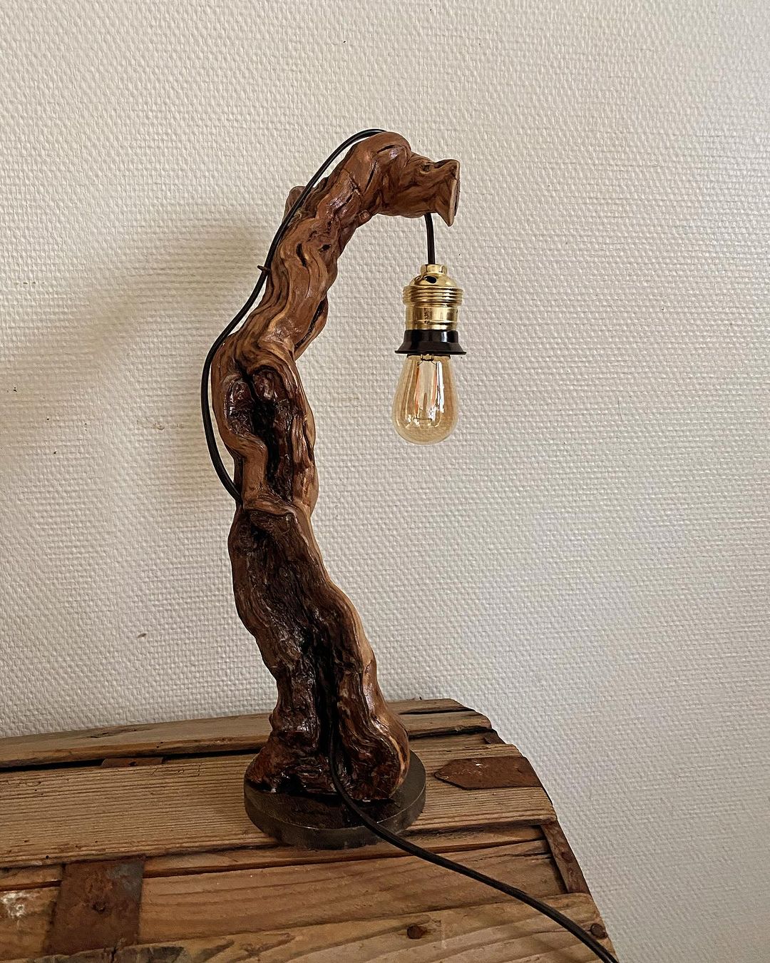 A unique wooden table lamp with an exposed Edison bulb