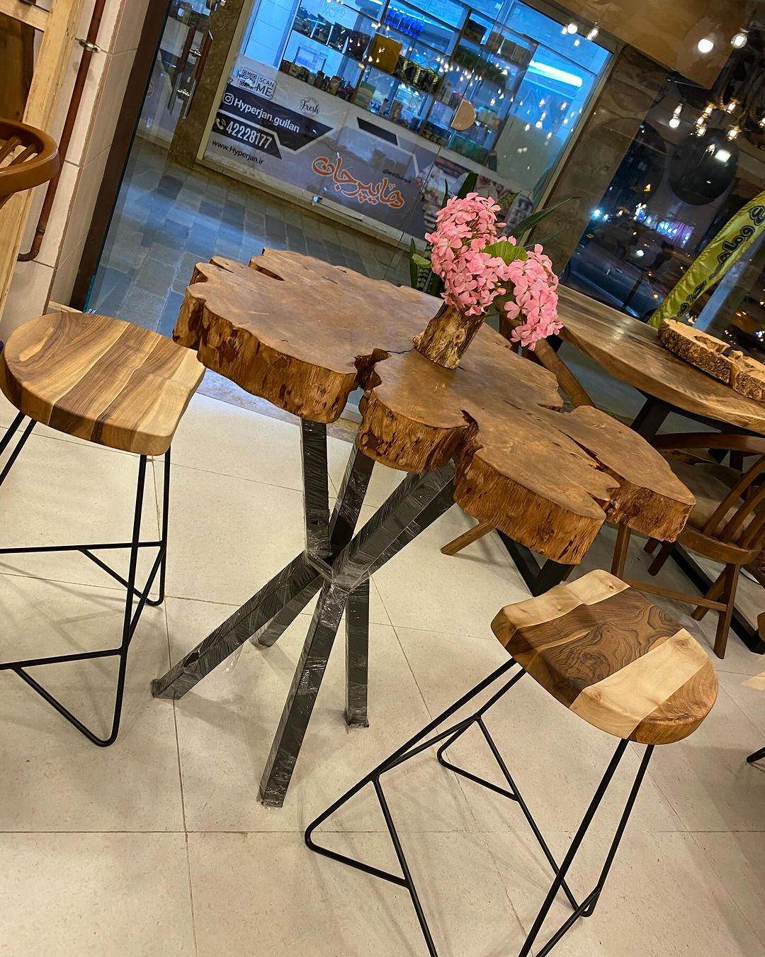 A rustic style cafe setup with live-edge tables combined with black geometric metal bases