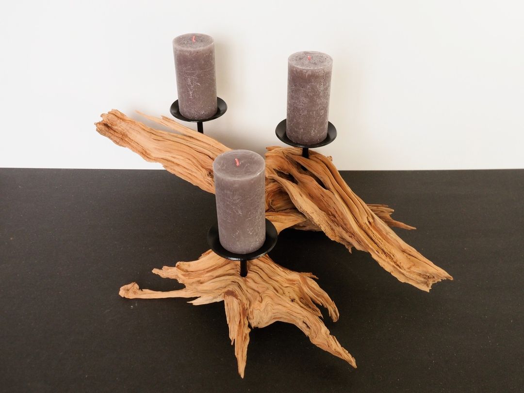 A unique candle holder featuring **driftwood** and _muted grey_ candles