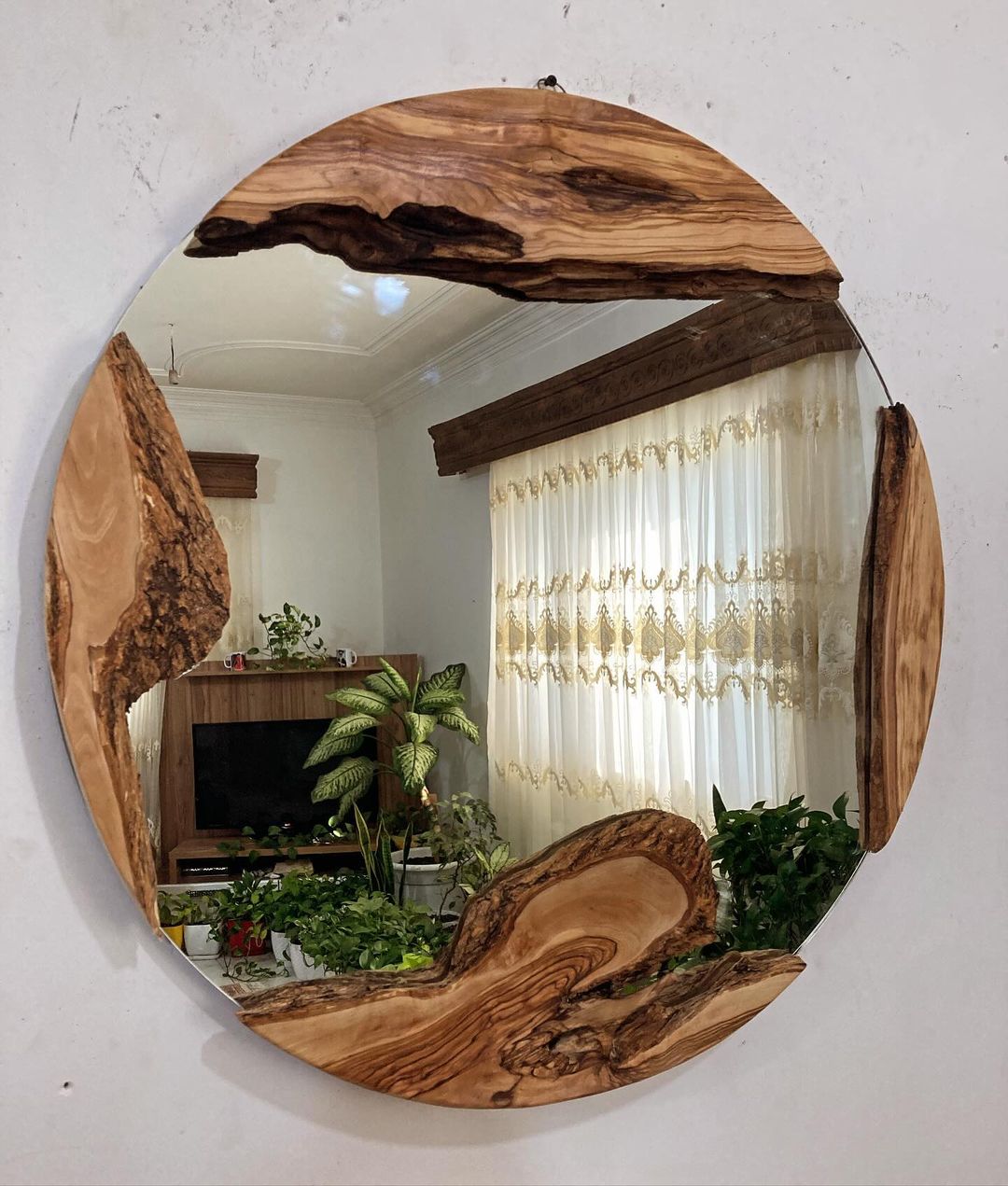 A uniquely crafted circular mirror with natural wooden frame