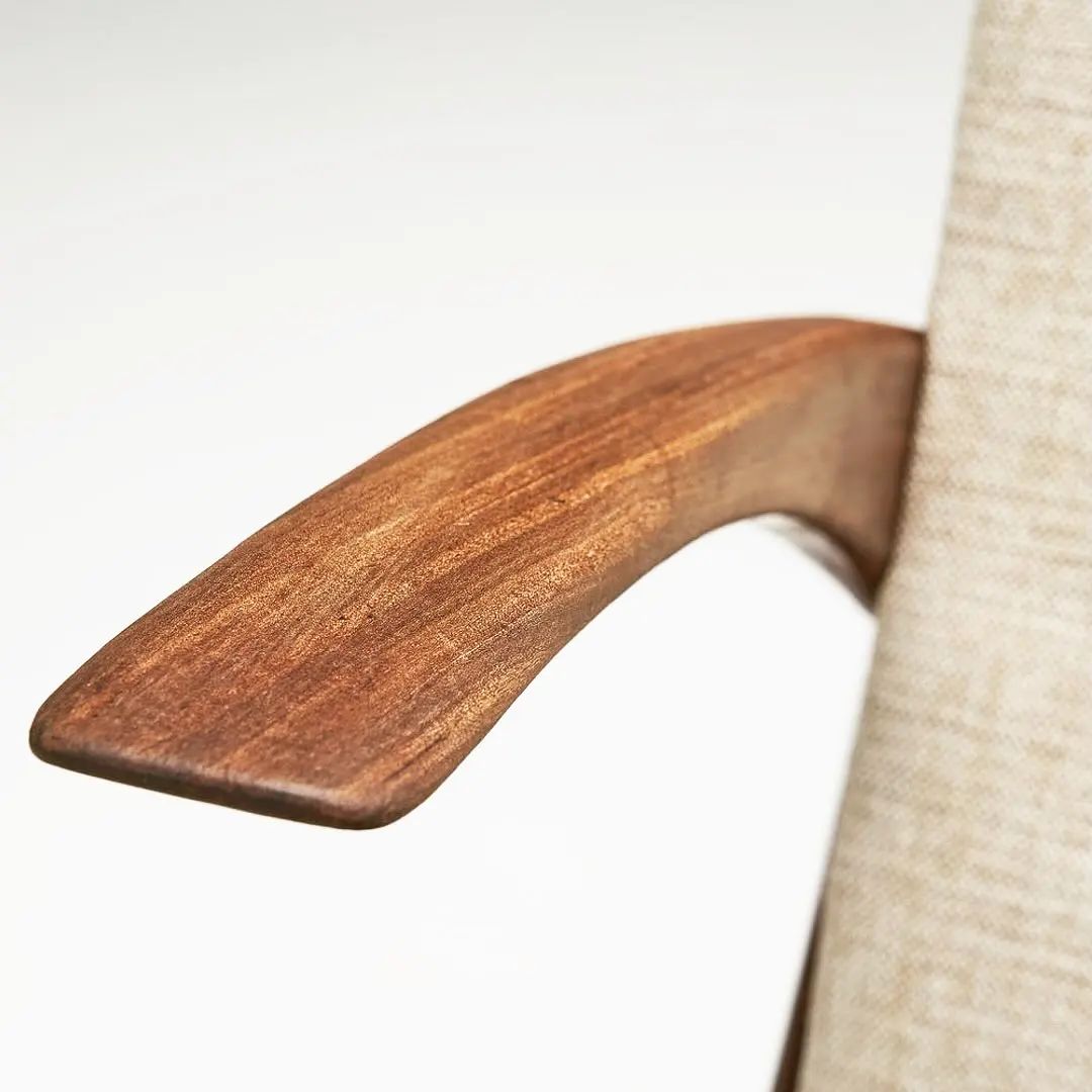 Close-up view of a wooden furniture armrest with fabric upholstery