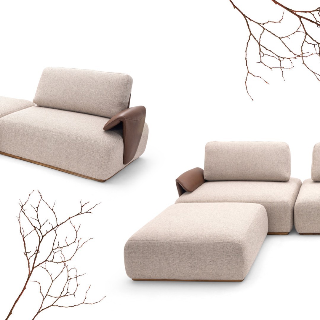 A contemporary modular sofa with neutral beige upholstery and chic leather accents.