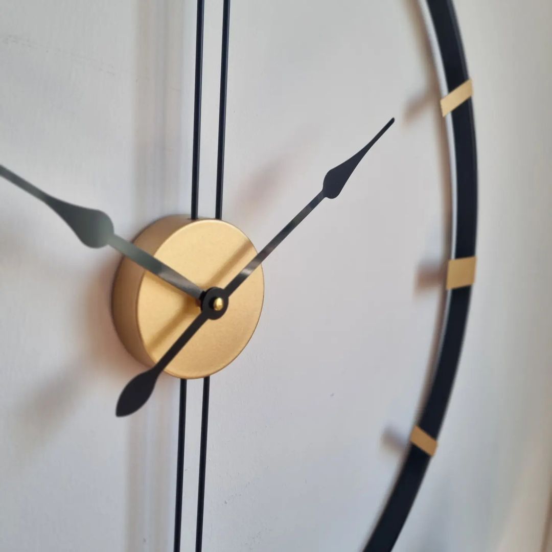 A minimalist wall clock with a golden center and black hands