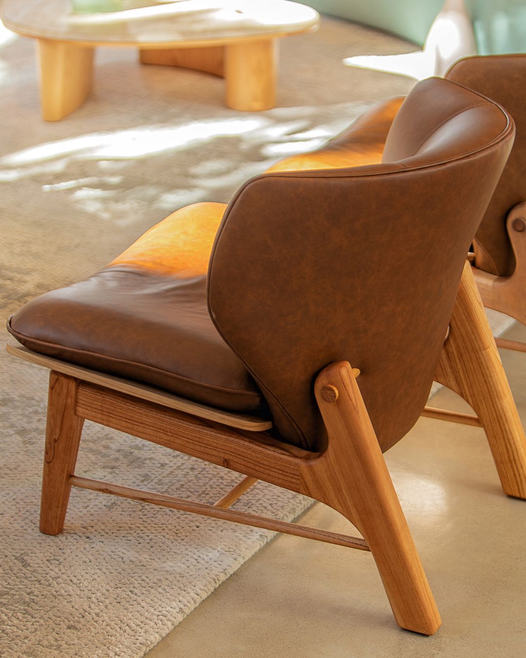 A modernist wooden armchair with sleek leather upholstery