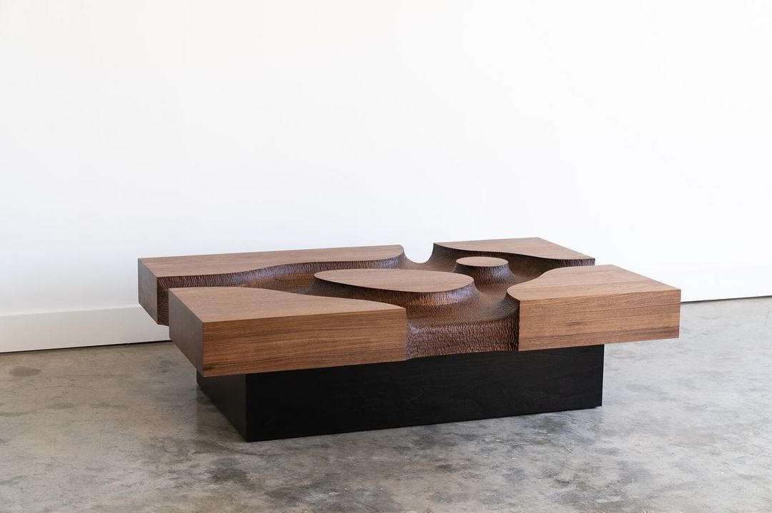 A sculptural wooden coffee table with a carved-out center