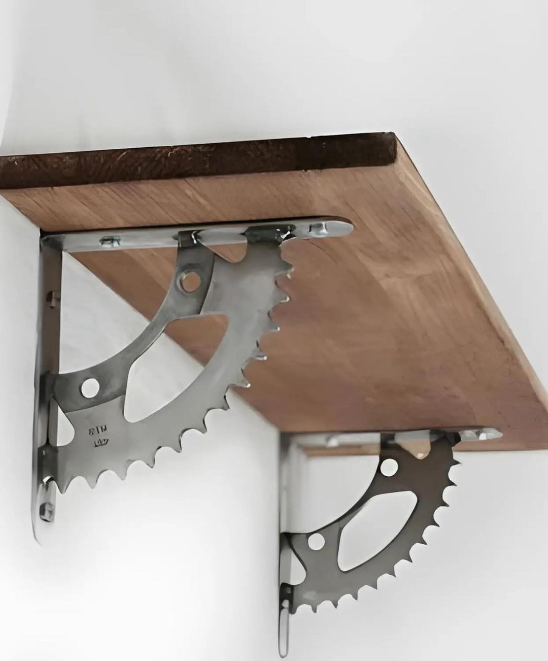 A uniquely designed shelf bracket made from repurposed bicycle chainrings