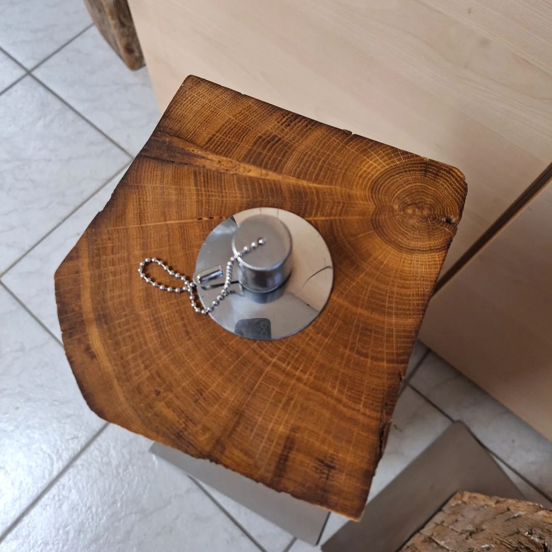 A unique wooden doorstop with a metallic grip