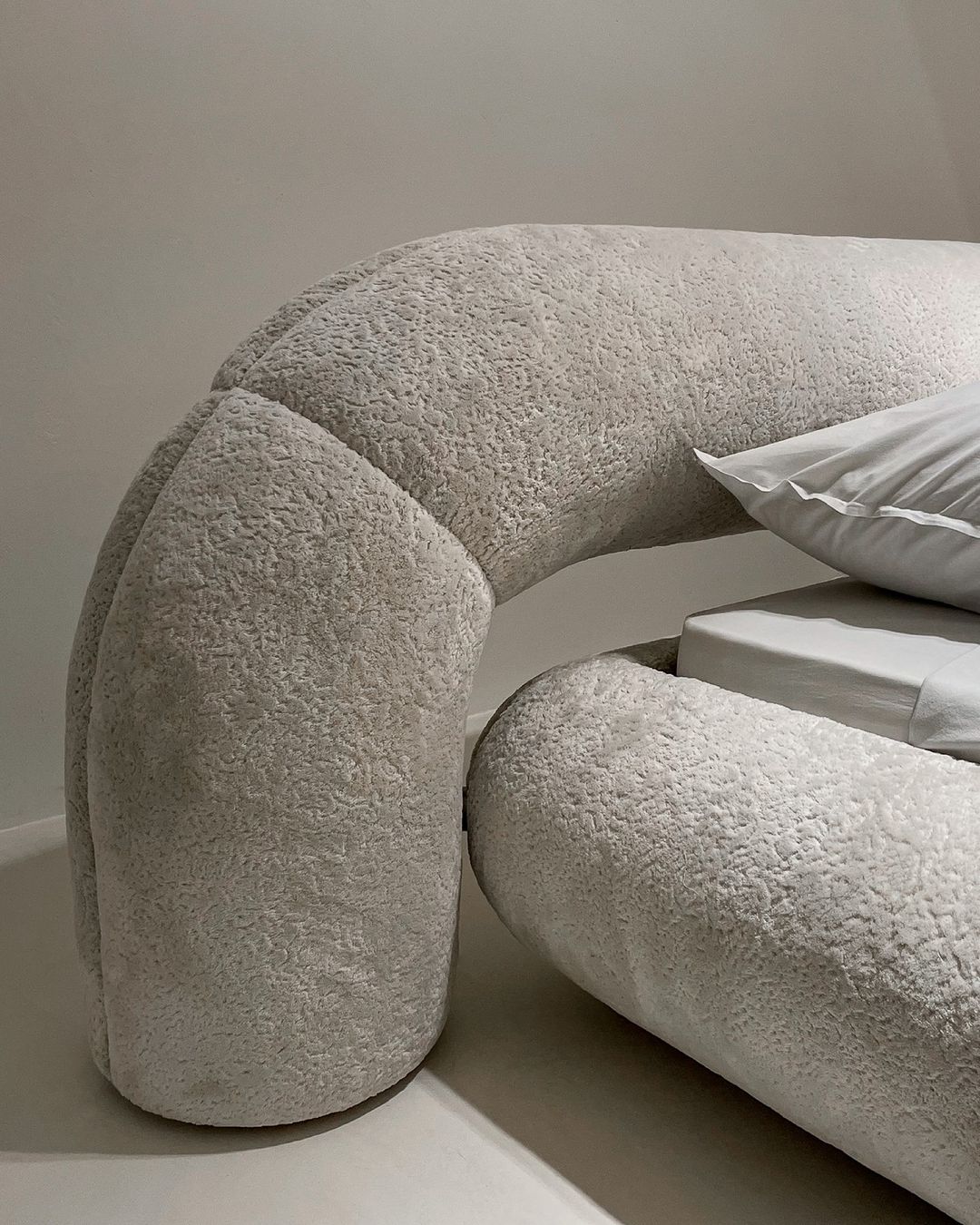 A unique curved sofa with plush teddy fabric