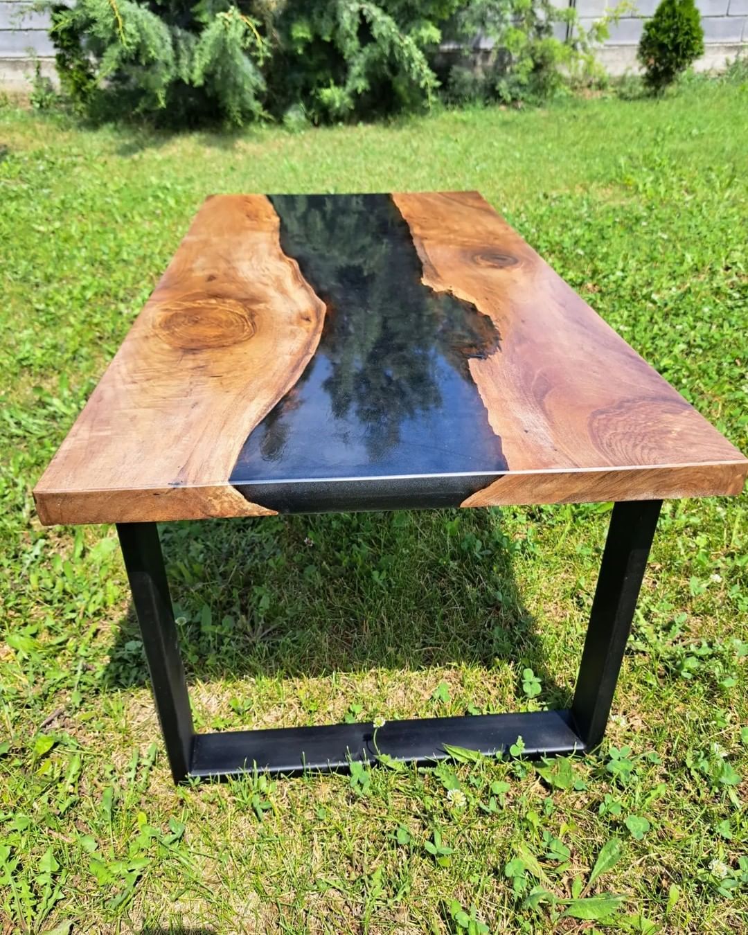 A handcrafted wooden and resin table set outdoors