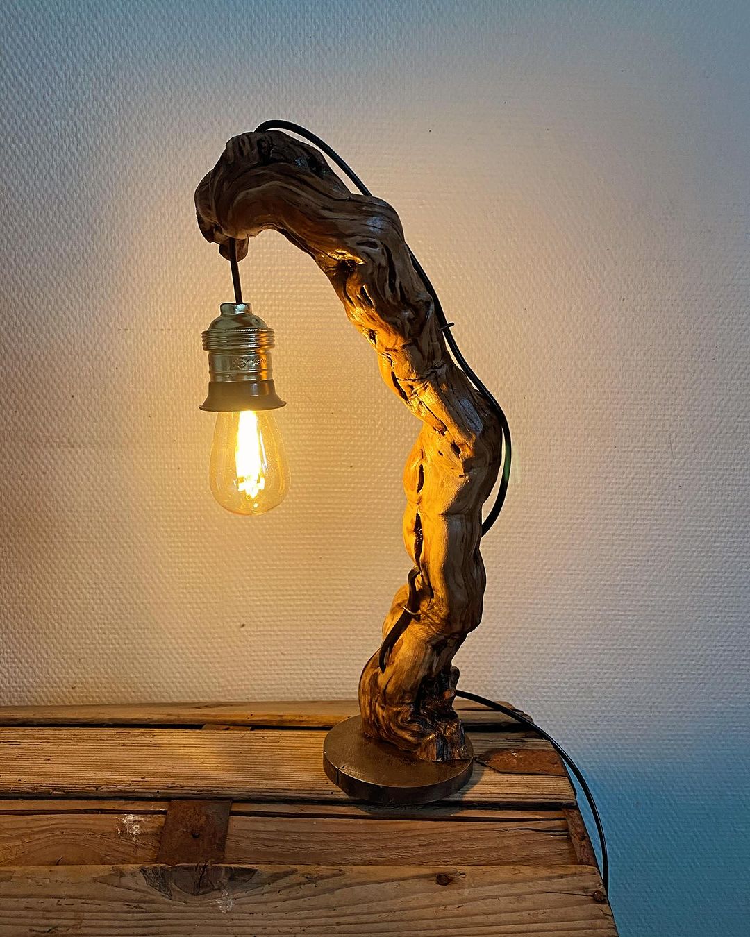 A unique and rustic driftwood table lamp illuminating a warm glow