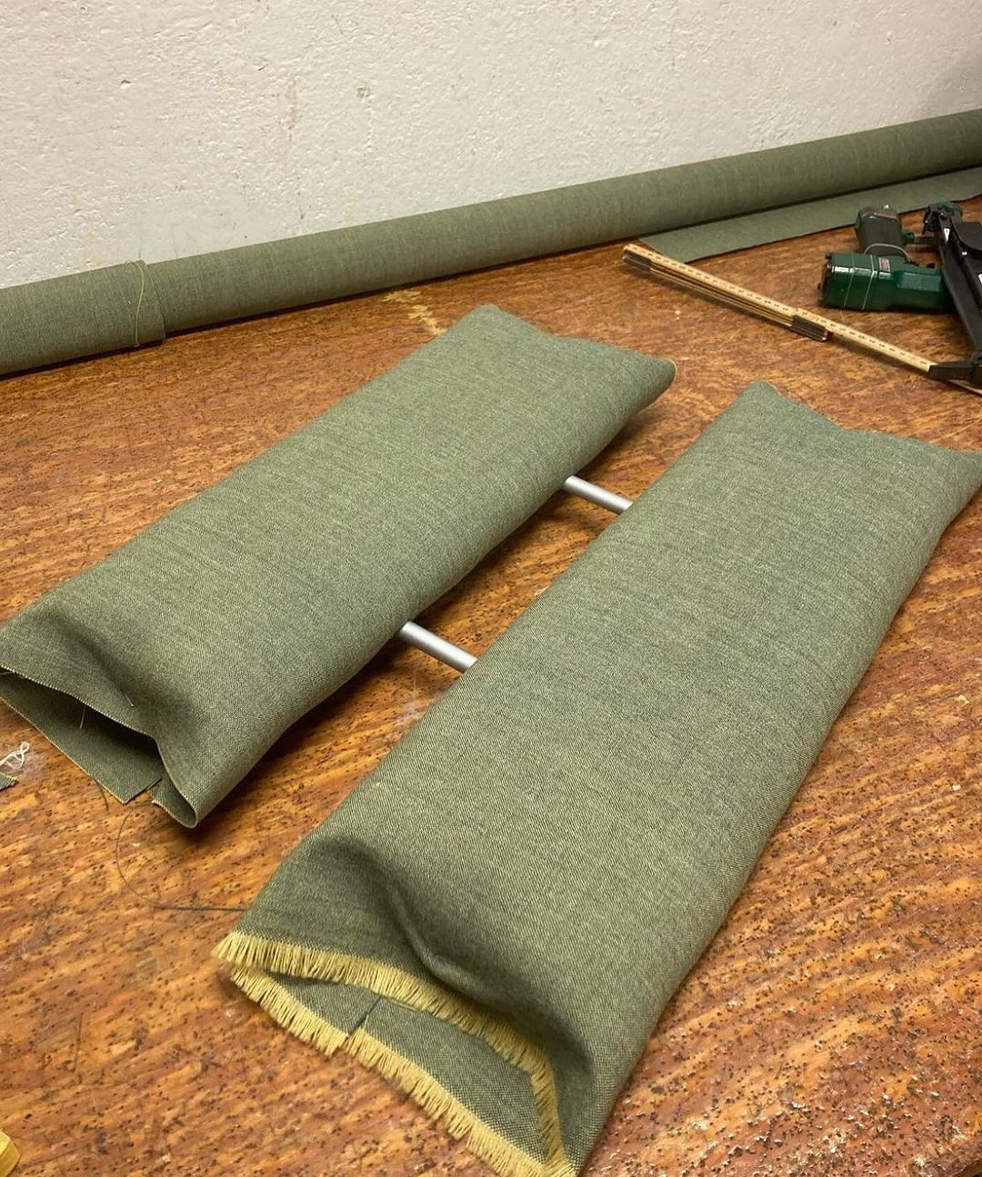 Handcrafted bolster pillows on a workbench