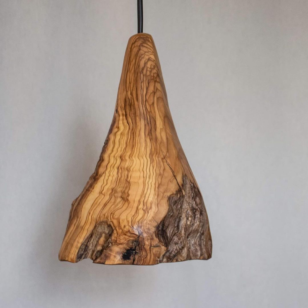 A handcrafted wooden pendant light with a natural finish and unique grain patterns