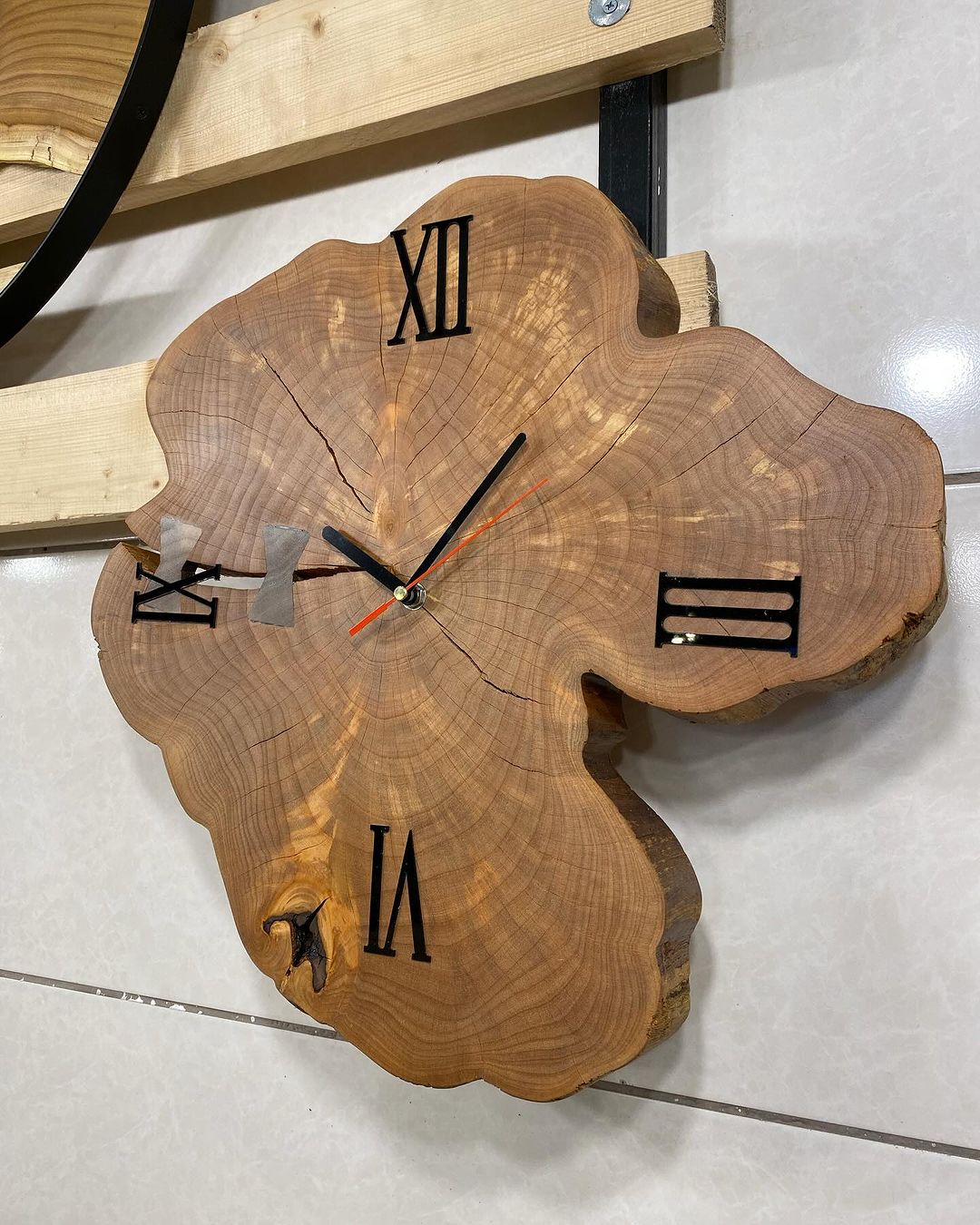 A handmade wooden wall clock with carved Roman numerals