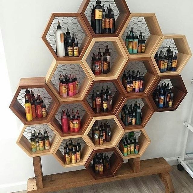 Hexagonal shelves filled with colorful beard oil bottles