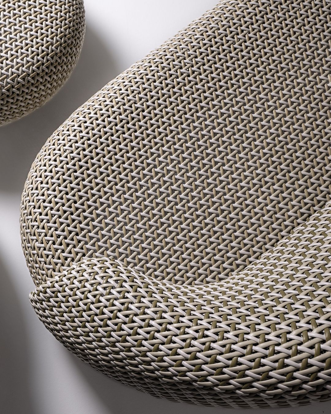 A close-up of a woven chair with an intricate herringbone pattern.