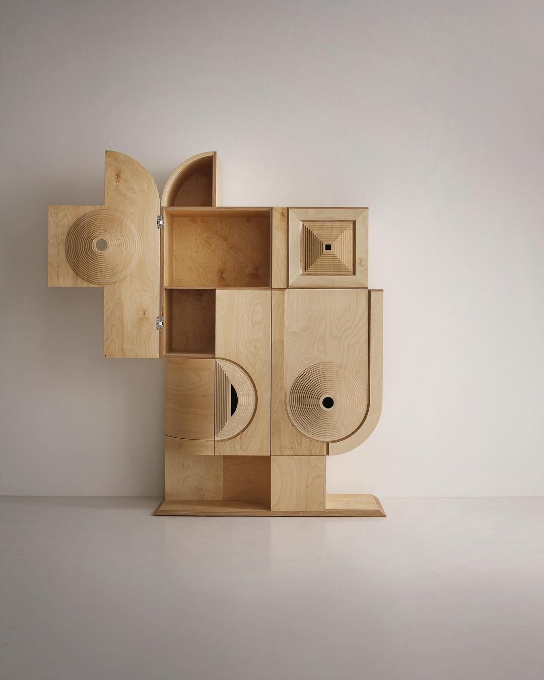 An inventive wooden cabinetry piece with open compartments and circular cut-out details