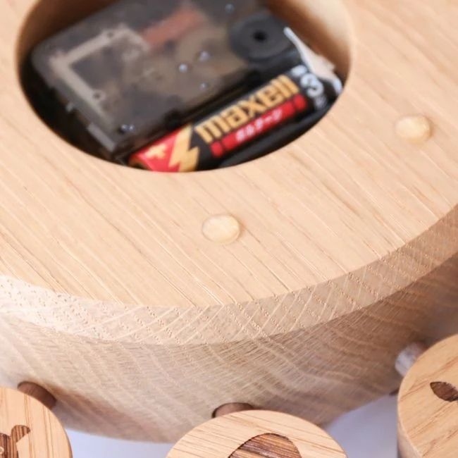 A neatly designed wooden tape dispenser with a visible Maxell tape inside