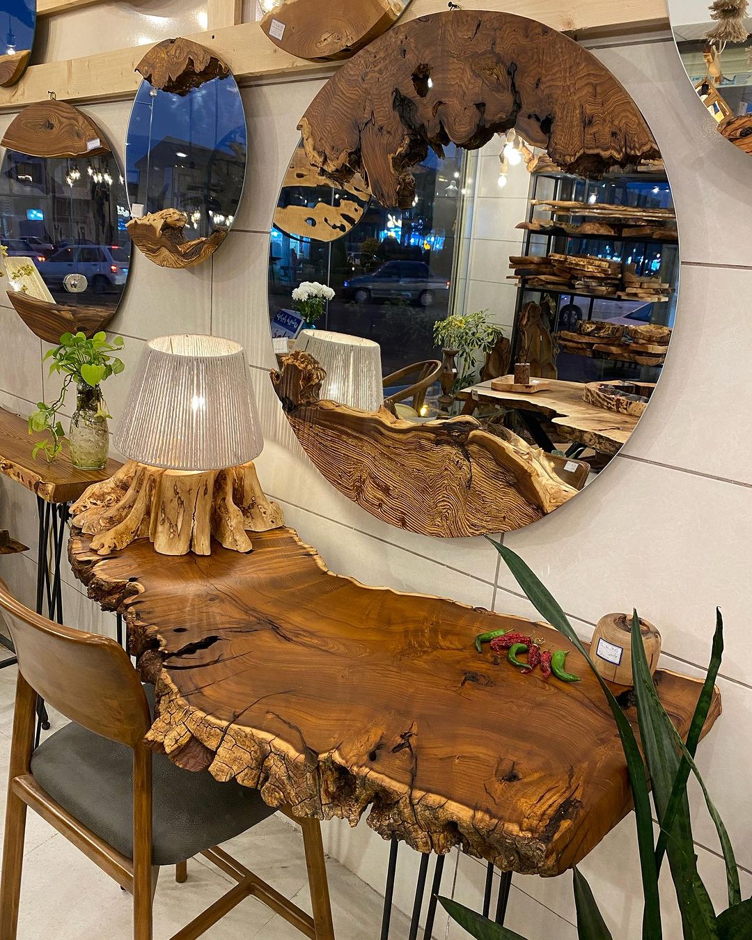 A uniquely crafted natural-edge wooden table with complementing rustic wood-framed mirrors.