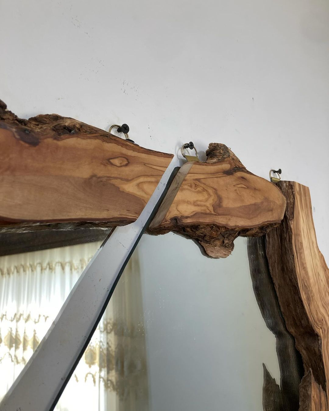 A unique live edge wood mirror design demonstrating organic contours and modern minimalist aesthetics