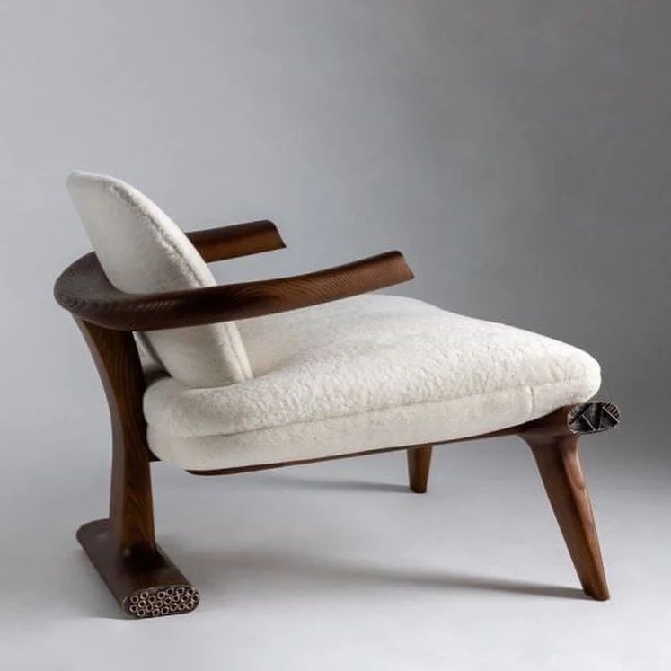 A modern mid-century styled armchair with textured white upholstery and distinctive wooden accents.