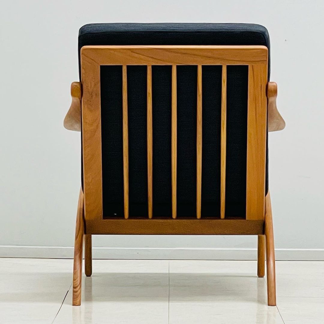 A mid-century modern chair with a wooden frame and black upholstery