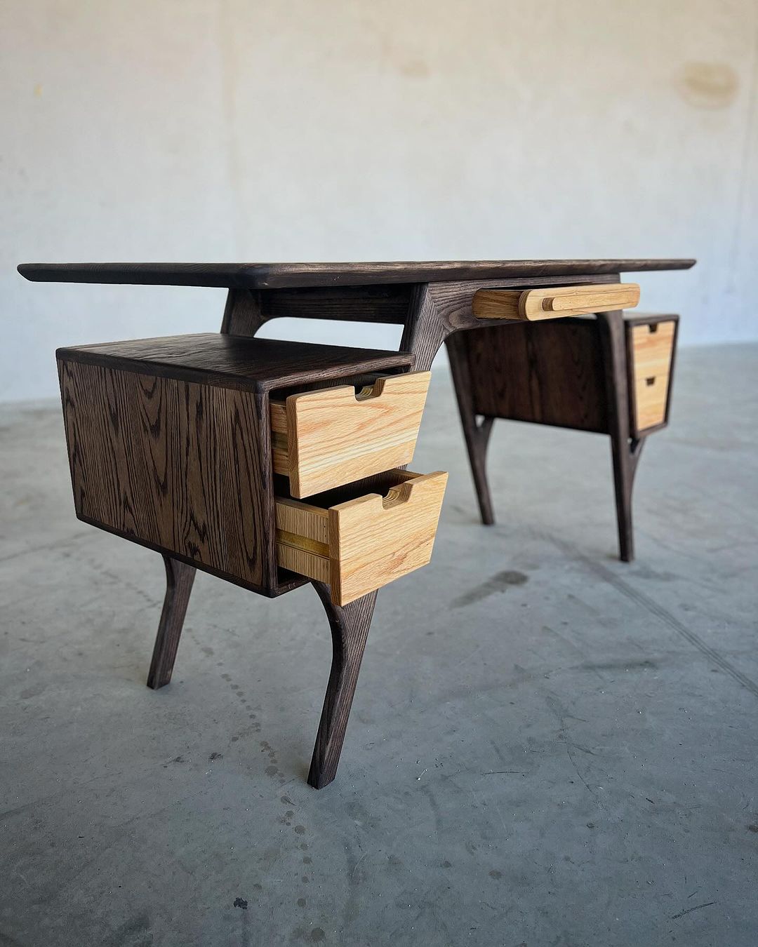 A modern mid-century desk with contrasting wood tones and sleek design