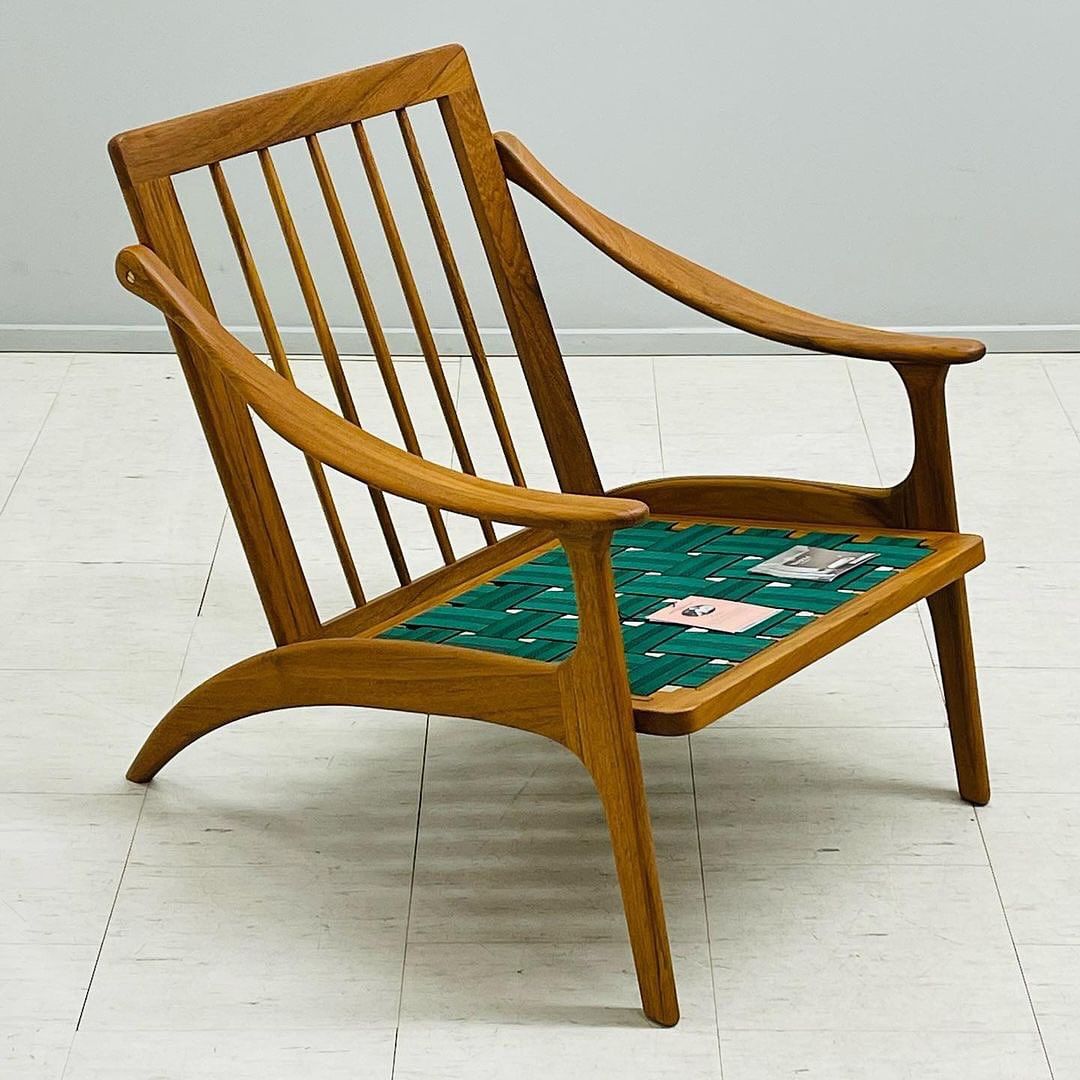 A wooden armchair with green webbing