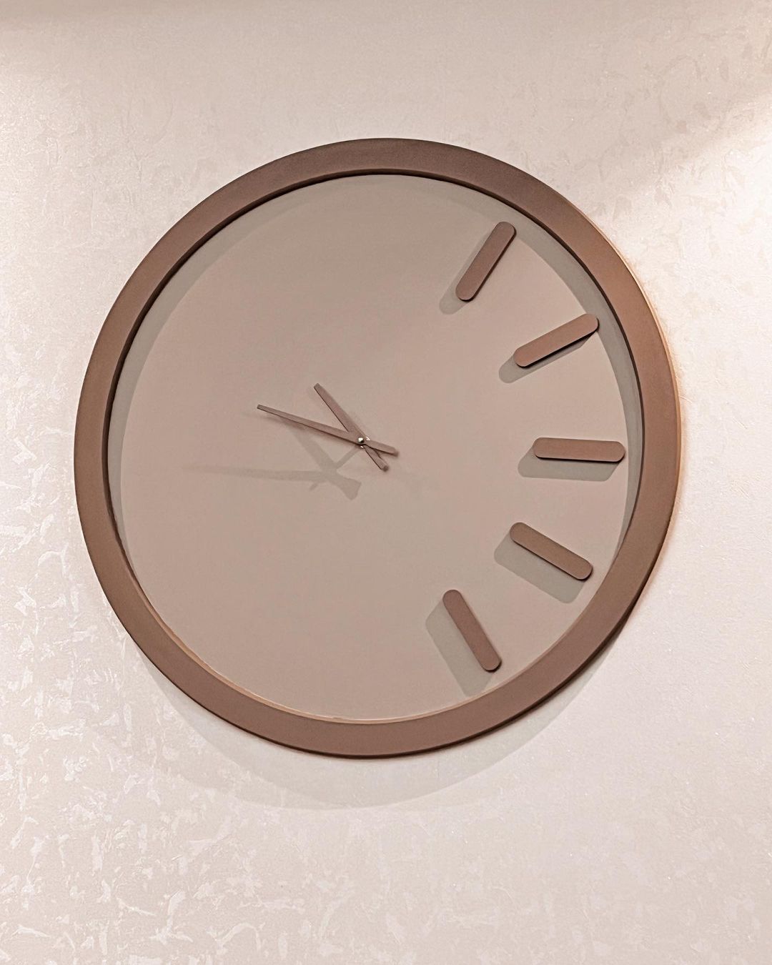 A minimalist design wall clock with a simple, uncluttered face